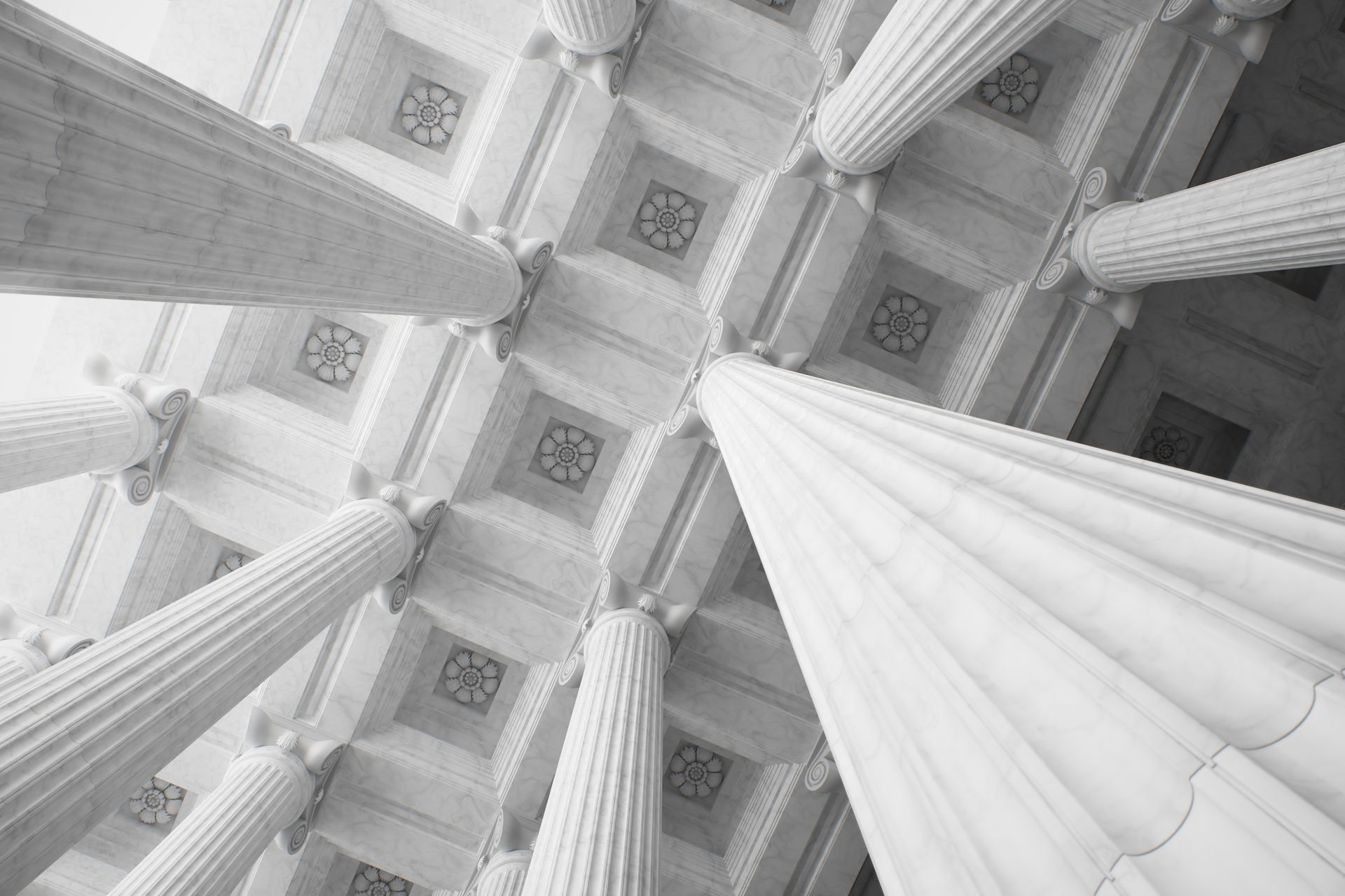 Vue vers les hautes colonnes de pierre et les panneaux de plafond ornés d'un bâtiment classique.