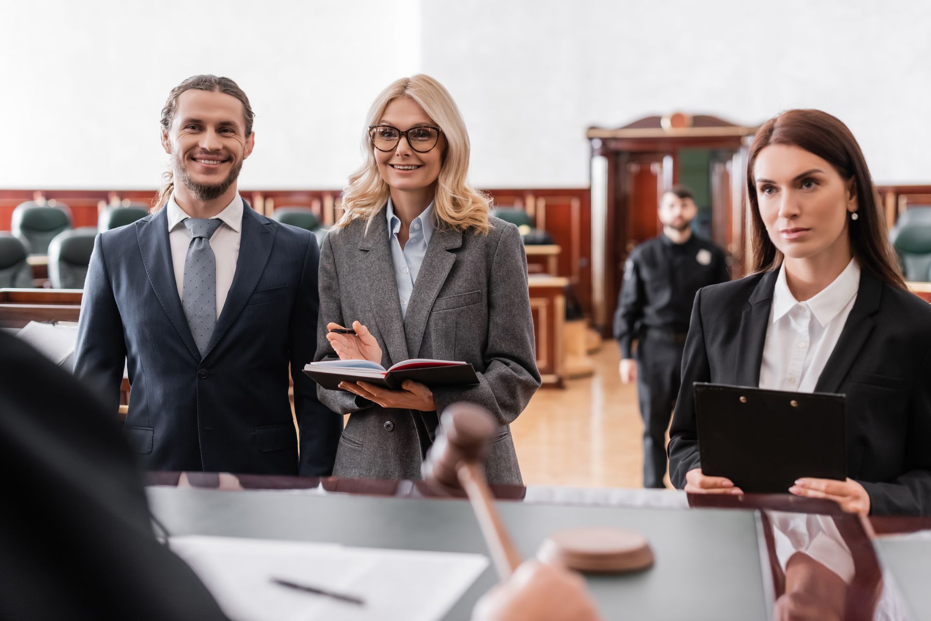 Deux avocates et un client devant le bureau d'un juge dans une cour de justice.