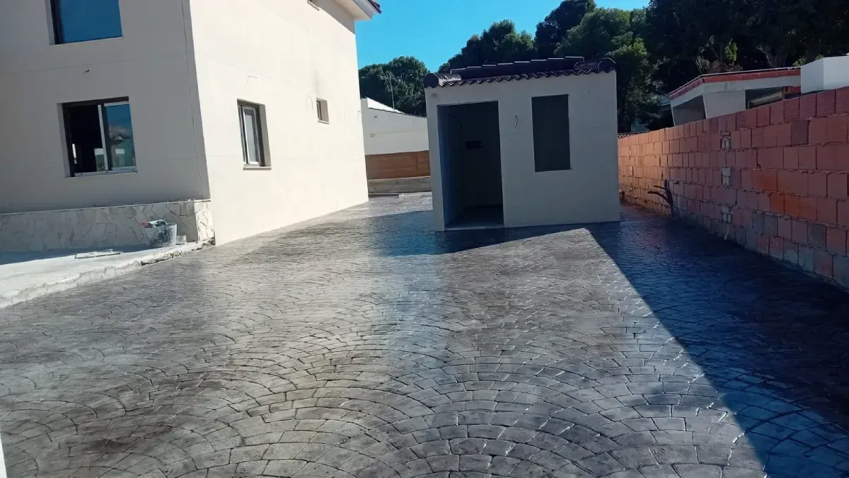 Una piscina de hormigón sin terminar en un entorno al aire libre con hormigón rugoso a su alrededor.