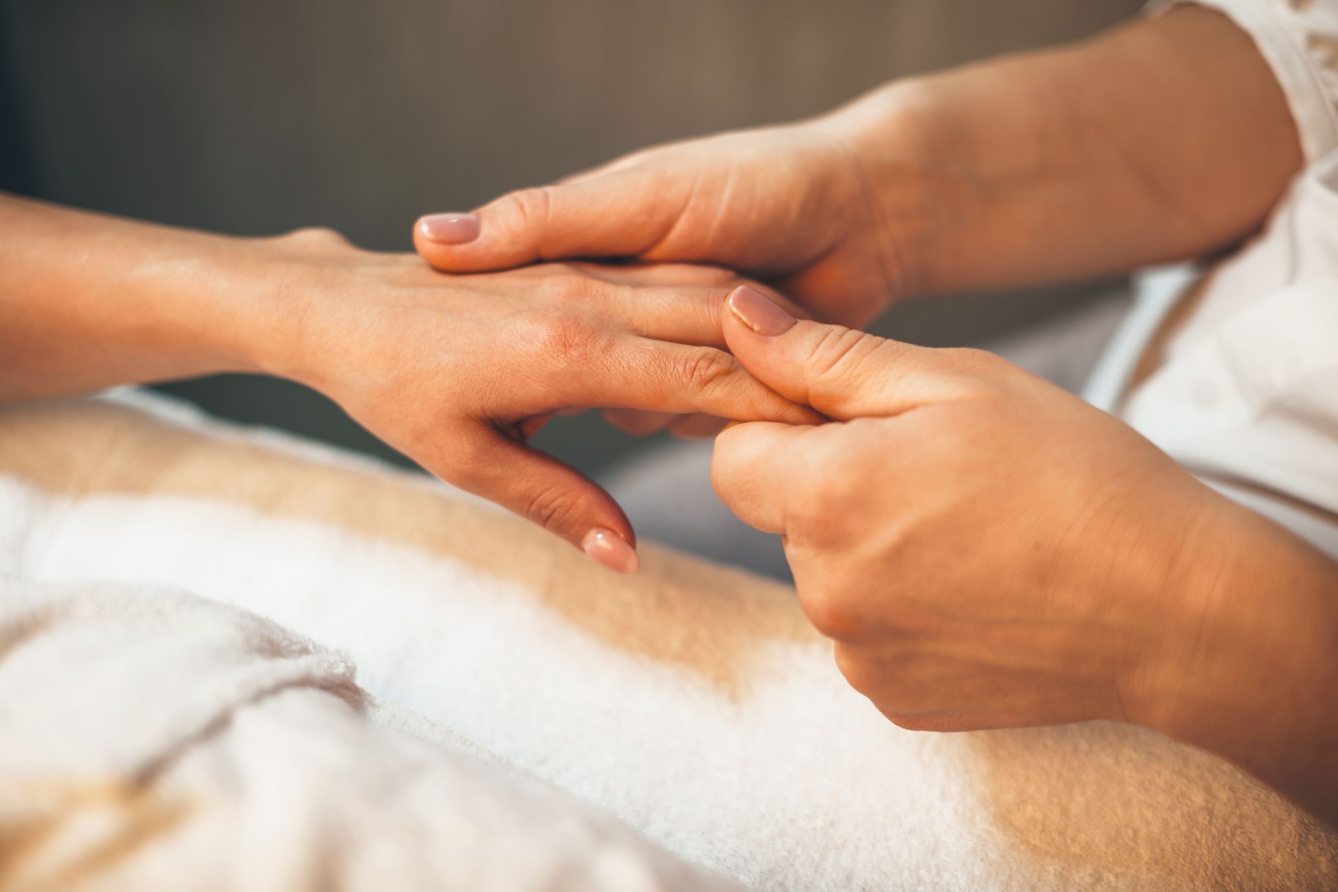 Hände, die eine Handmassage erhalten. Nahaufnahme einer Hand, die von einer anderen gehalten und massiert wird.