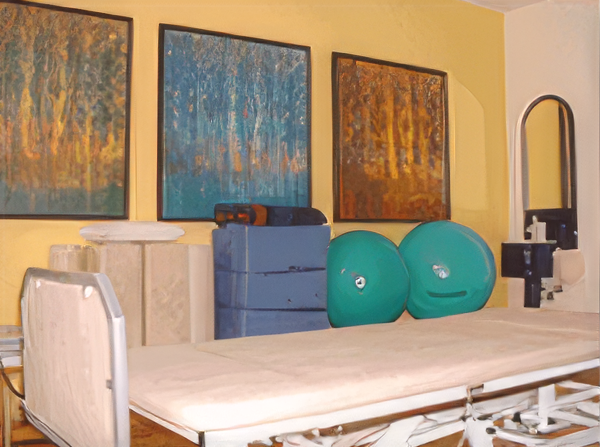 Wartezimmer mit drei Stühlen, einem Schrank mit Fernseher und einer Tür, die in einen anderen Raum führt.