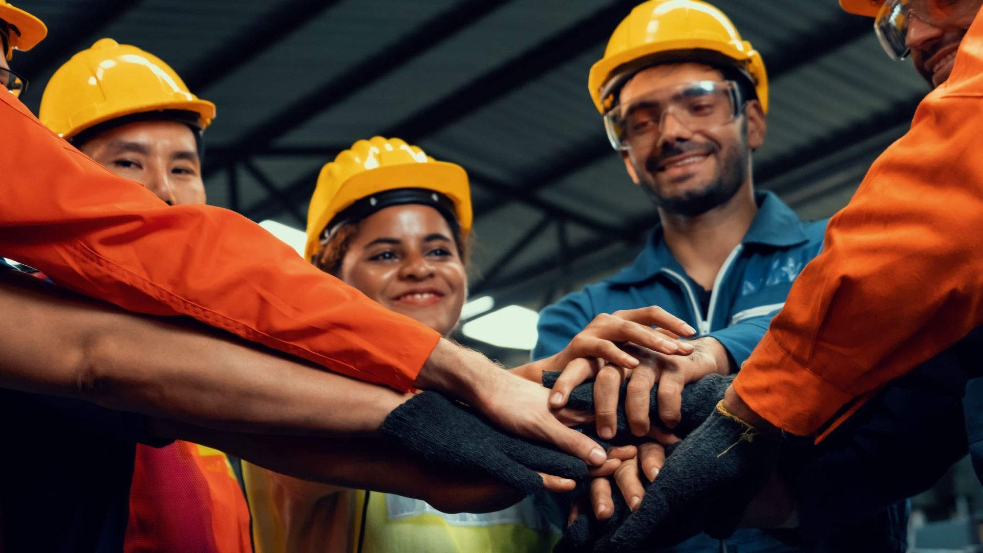 Un grupo de trabajadores de la construcción están juntando sus manos.