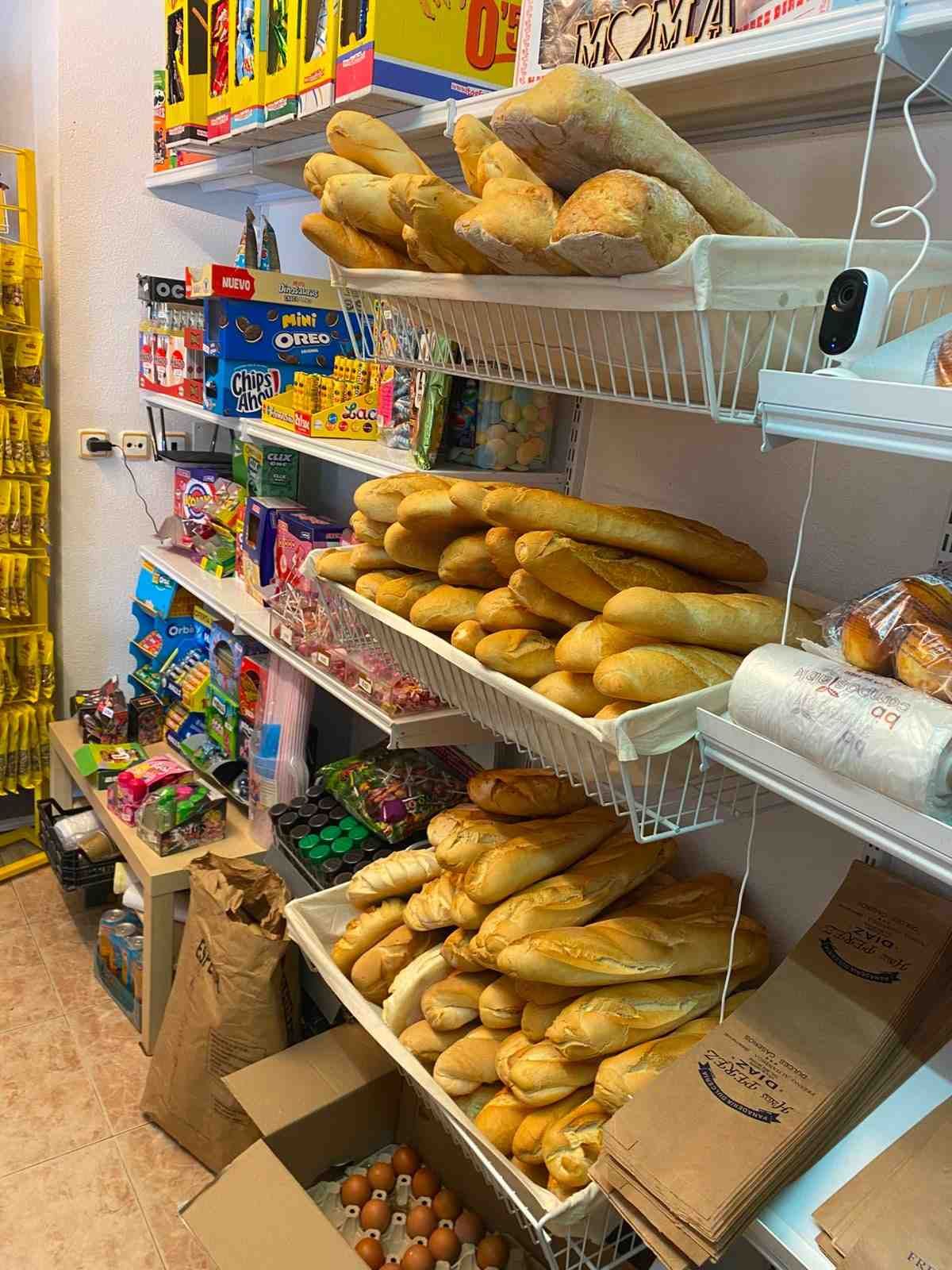 Estantes de un supermercado repletos de baguettes y aperitivos envasados.