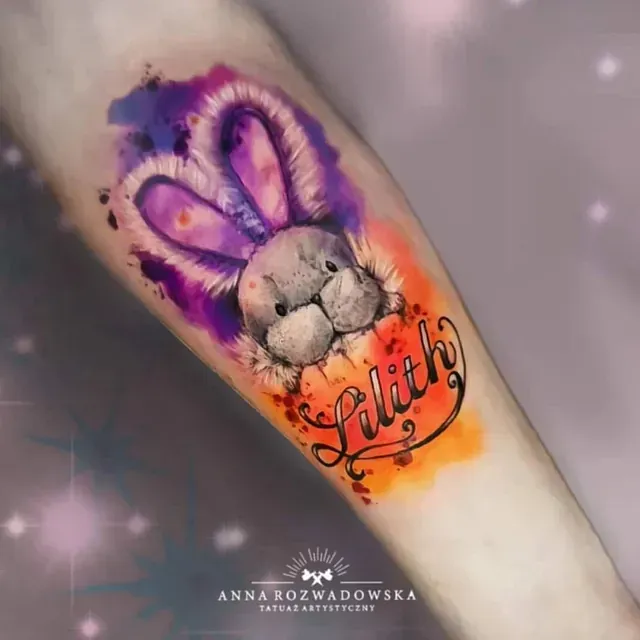 Ein Tattoo eines Stoffhasen mit dem Namen Lilith darauf