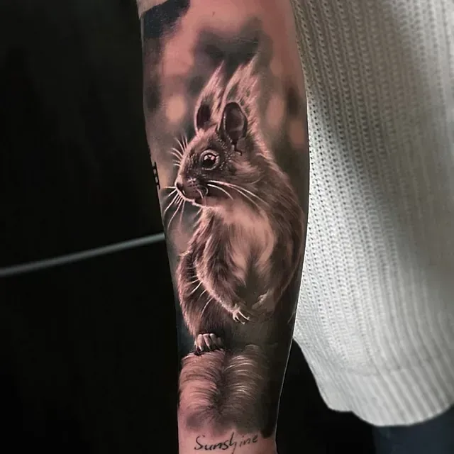 Eine Person hat ein Eichhörnchen-Tattoo auf dem Unterarm.