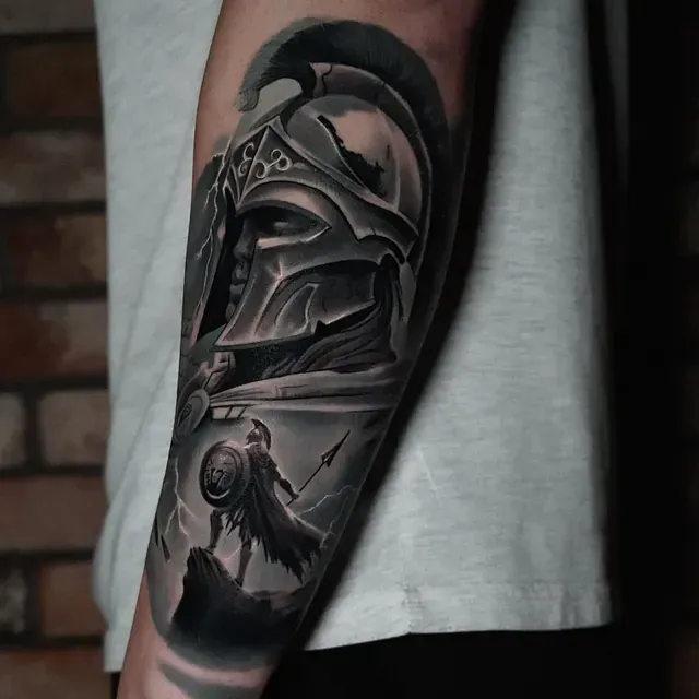 Ein Mann hat die Tätowierung eines spartanischen Kriegers auf seinem Unterarm.