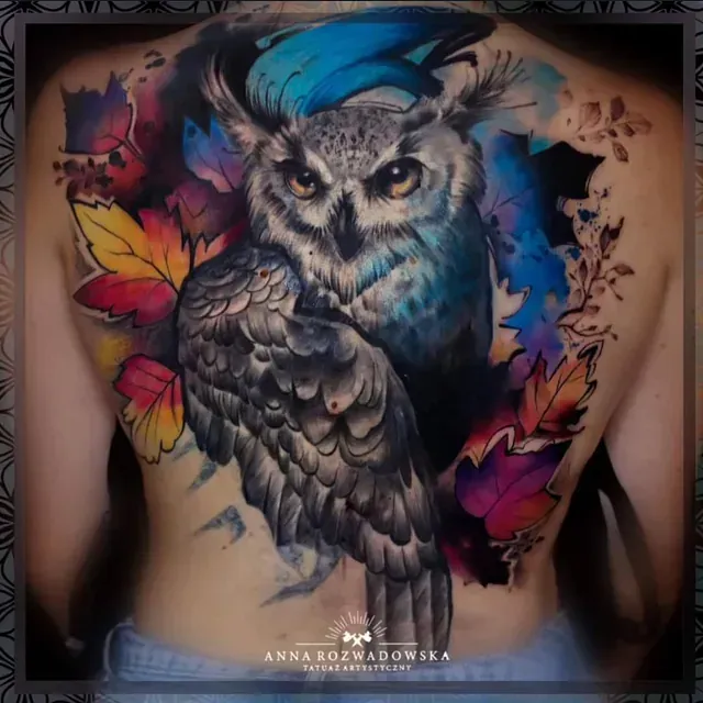 Eine Frau hat ein buntes Eulentattoo auf dem Rücken