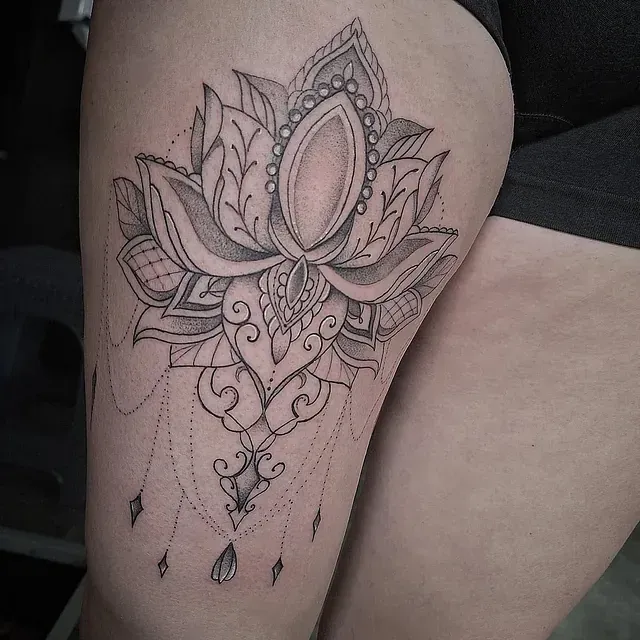 Eine Frau hat eine Lotusblumentätowierung auf ihrem Oberschenkel.