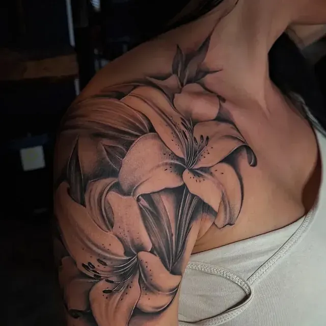 Eine Frau hat eine Blumentätowierung auf ihrer Schulter