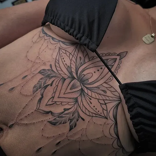 Eine Frau hat eine Tätowierung einer Blume auf ihrer Brust