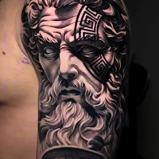 Ein Mann hat auf seinem Arm eine Tätowierung der Statue eines Mannes mit Bart.