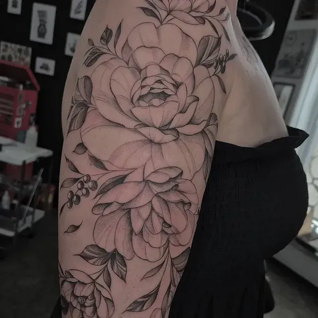 Eine Frau hat eine Blumentätowierung auf ihrem Arm