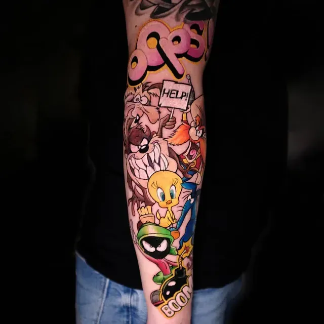 Eine Person hat eine Tätowierung mit Looney Tunes-Figuren auf dem Arm.