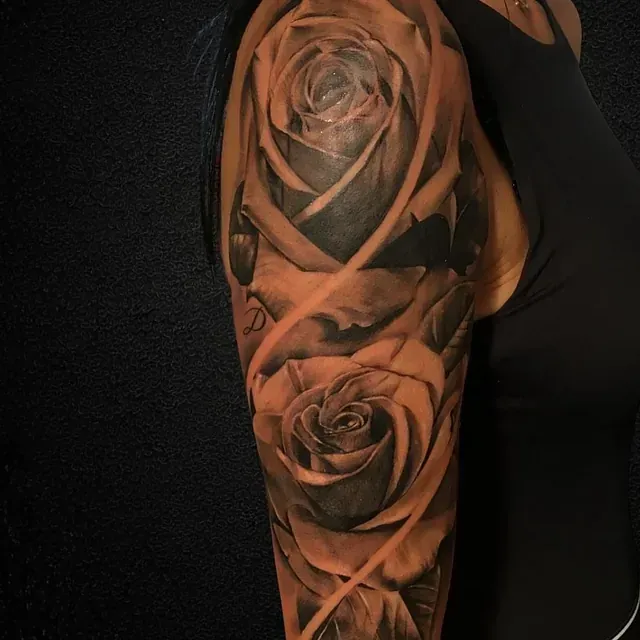 Eine Frau hat eine Rosentätowierung auf ihrem Arm.