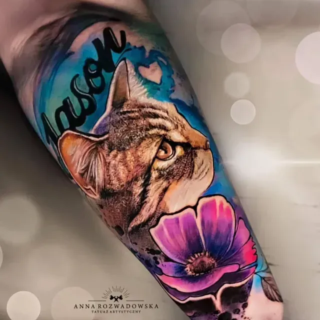 Ein Tattoo einer Katze und einer Blume auf dem Arm einer Person