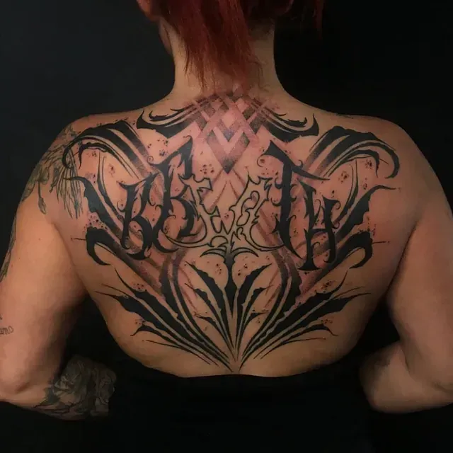 Eine Frau hat ein großes Tattoo auf ihrem Rücken mit der Aufschrift „worth“