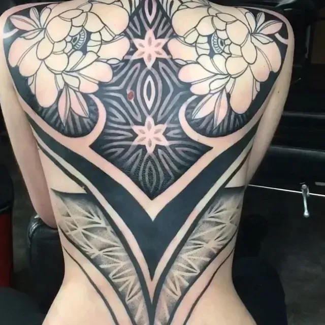 Eine Frau hat ein großes Tattoo auf dem Rücken