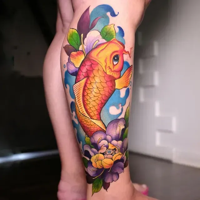 Eine Frau hat ein Tattoo mit einem Fisch und Blumen auf ihrem Bein