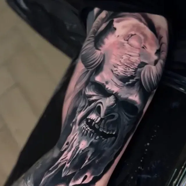 Eine Person hat eine Totenkopftätowierung auf dem Arm