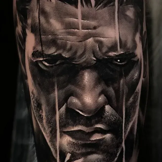 Eine schwarz-weiße Tätowierung des Gesichts eines Mannes.