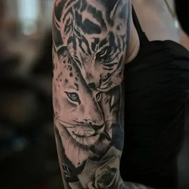 Eine Frau hat eine Tätowierung mit zwei Leoparden auf ihrem Arm.
