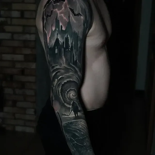 Ein Mann mit einem Ganzkörpertattoo einer Burg und Fledermäusen auf seinem Arm.