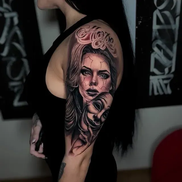 Eine Frau hat ein Tattoo mit einem Frauengesicht auf ihrem Arm.