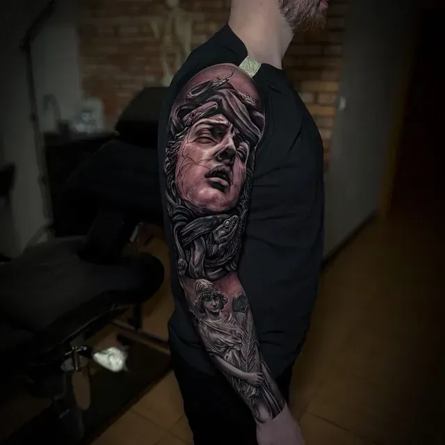 Ein Mann hat eine Statuetätowierung auf seinem Arm.