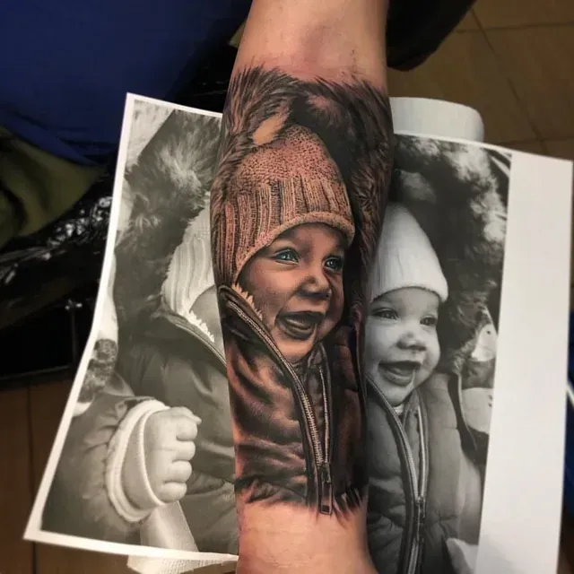 Eine Person hat eine Tätowierung eines Babys auf dem Arm