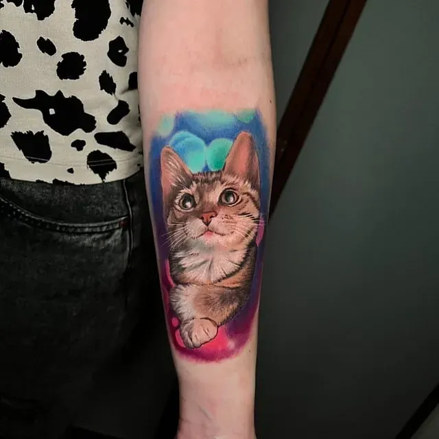 Eine Frau hat eine Katzentätowierung auf ihrem Unterarm