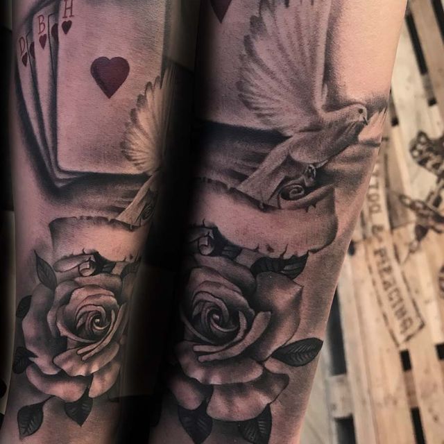 Ein schwarz-weißes Tattoo mit Rosen und Spielkarten