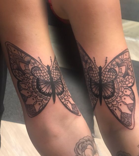 Eine Frau hat zwei Schmetterlinge auf ihren Armen tätowiert