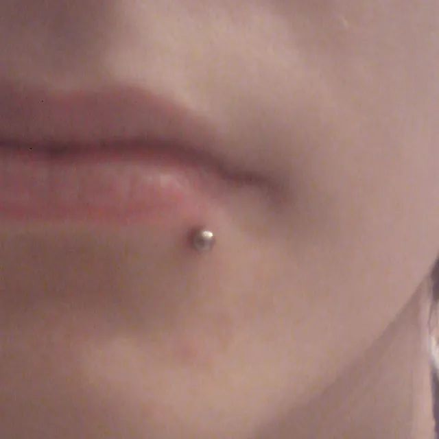 Eine Nahaufnahme des Gesichts einer Frau mit einem Piercing in ihrer Lippe.