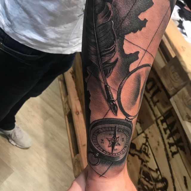 Ein Mann hat ein Kompass-Tattoo auf seinem Arm