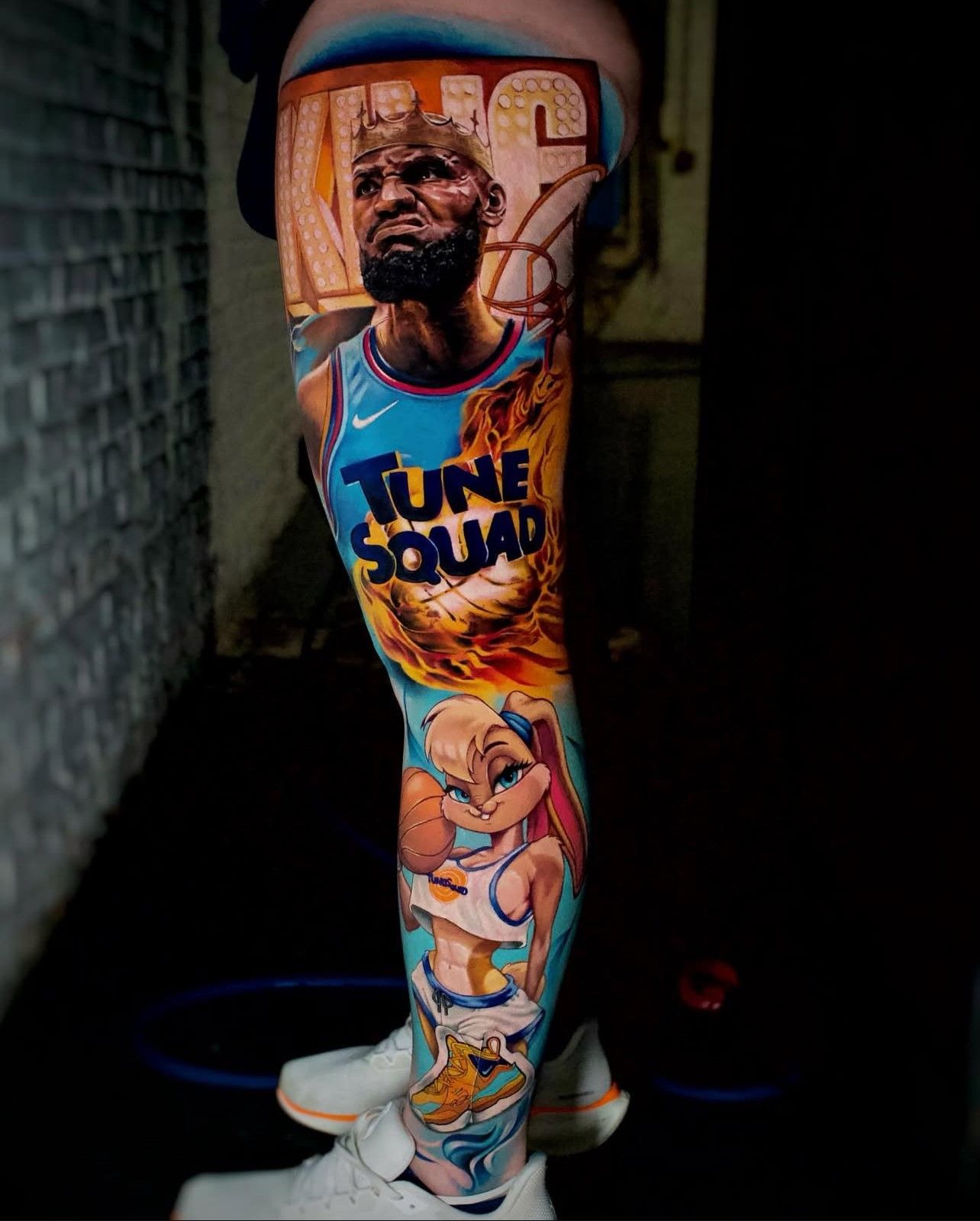 Eine Person hat die Tätowierung eines Basketballspielers auf ihrem Bein.