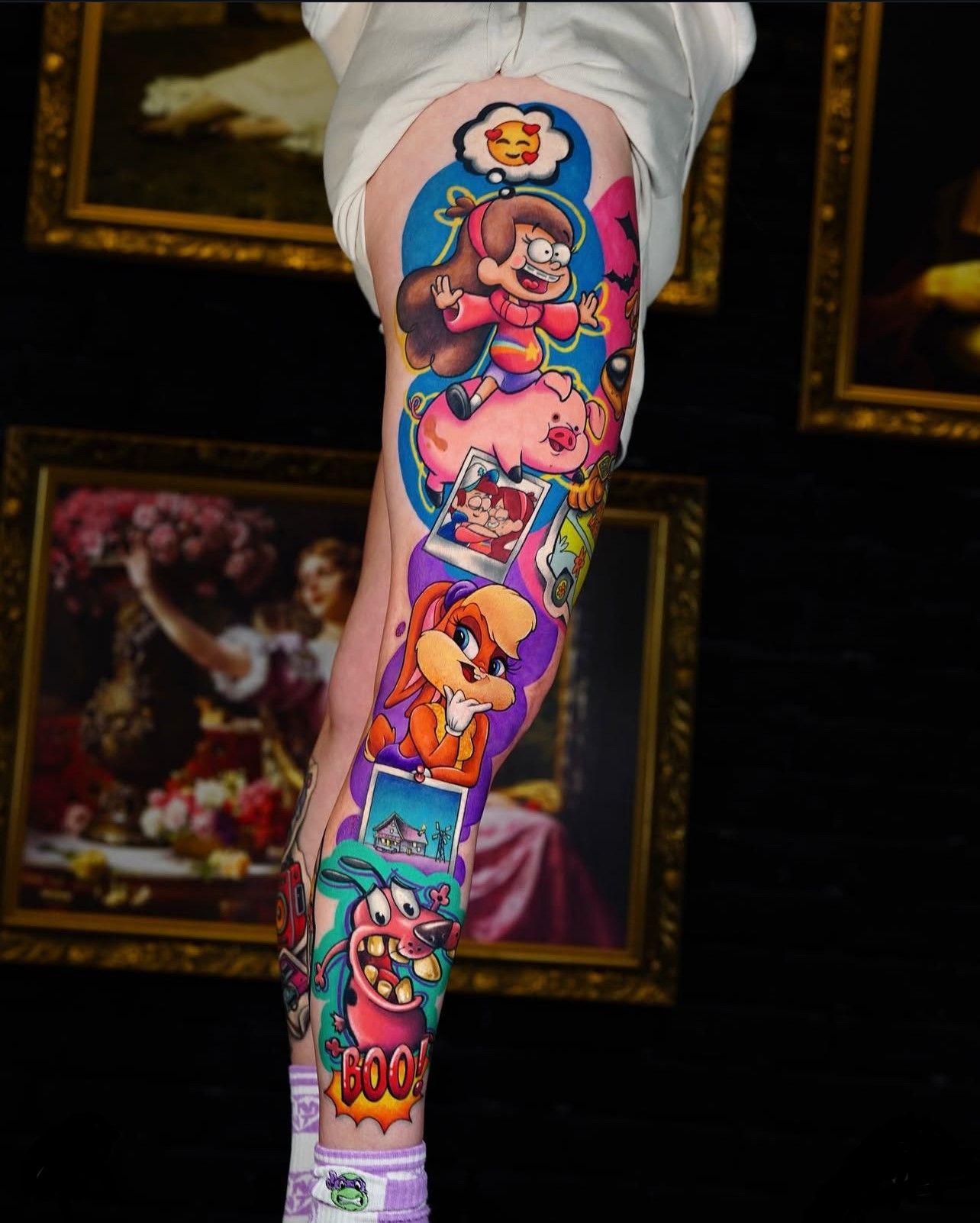 Eine Person hat ein Tattoo mit Comicfiguren auf ihrem Bein