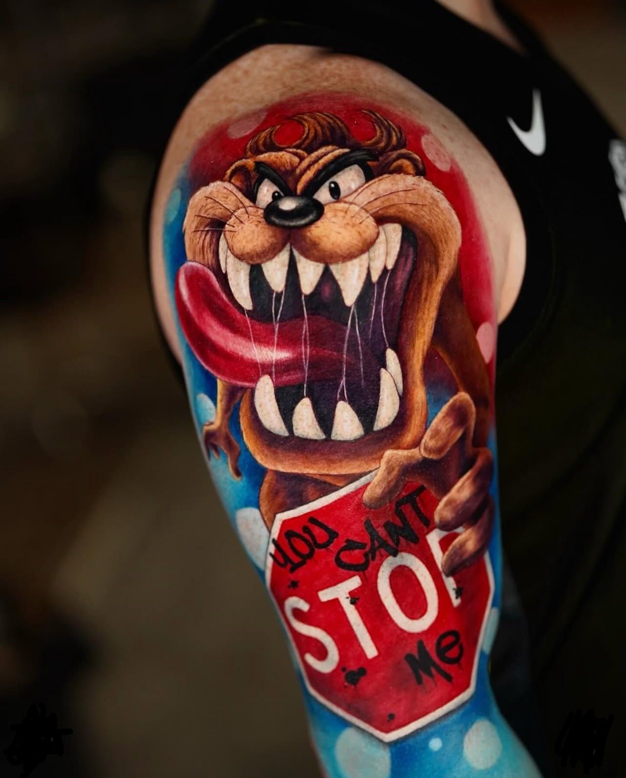 Eine Person hat ein Tattoo von Taz, der ein Stoppschild hält