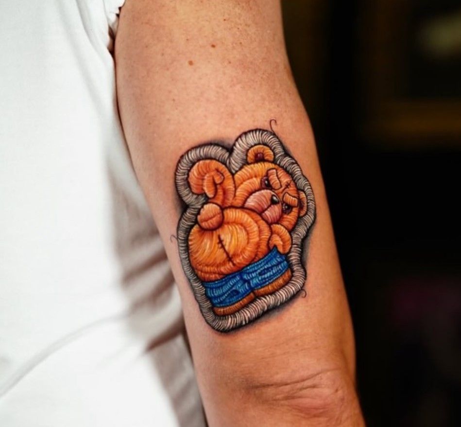 Eine Person hat eine Tätowierung eines Boxhandschuhs auf dem Arm