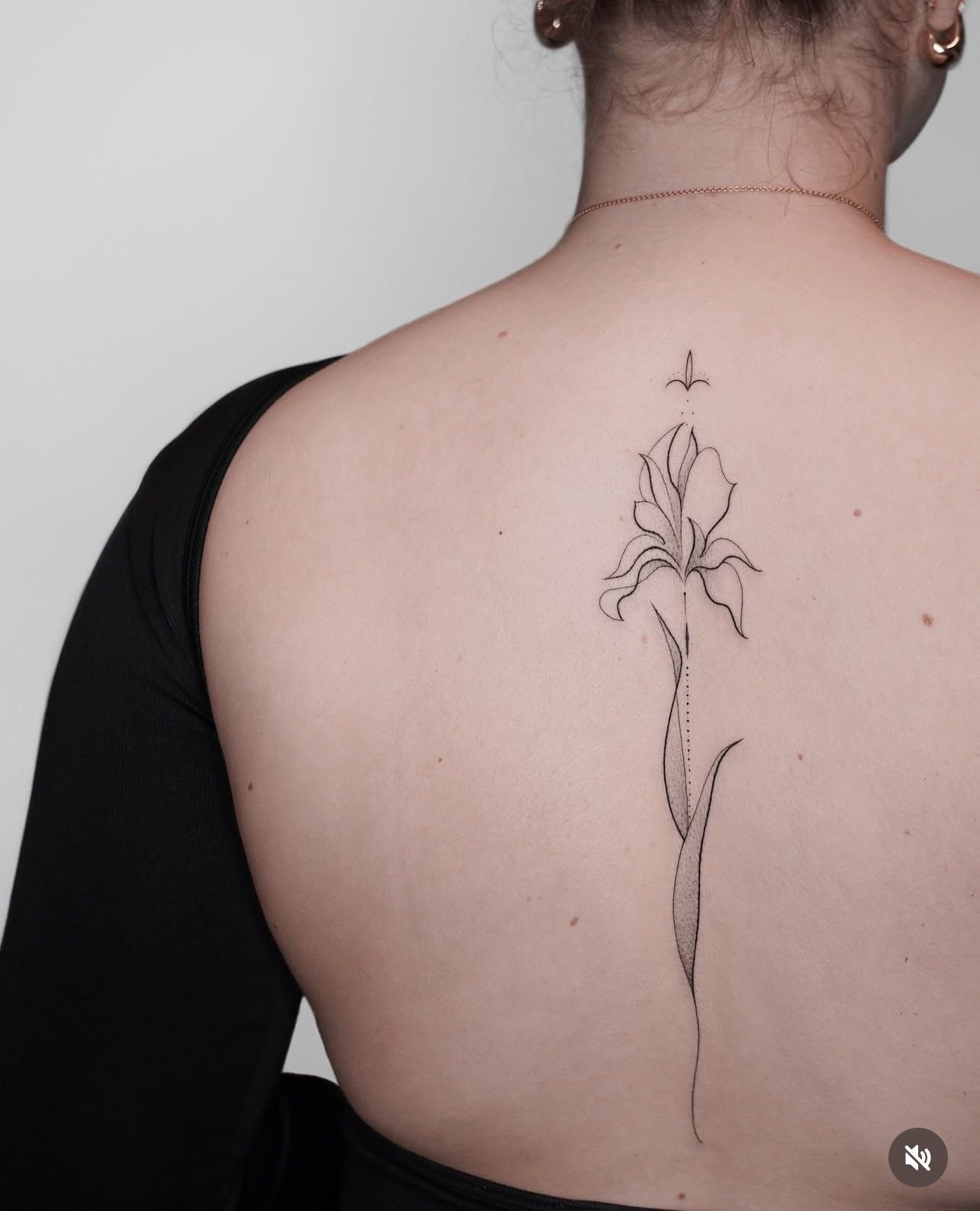 Eine Frau hat eine Blumentätowierung auf ihrem Rücken.