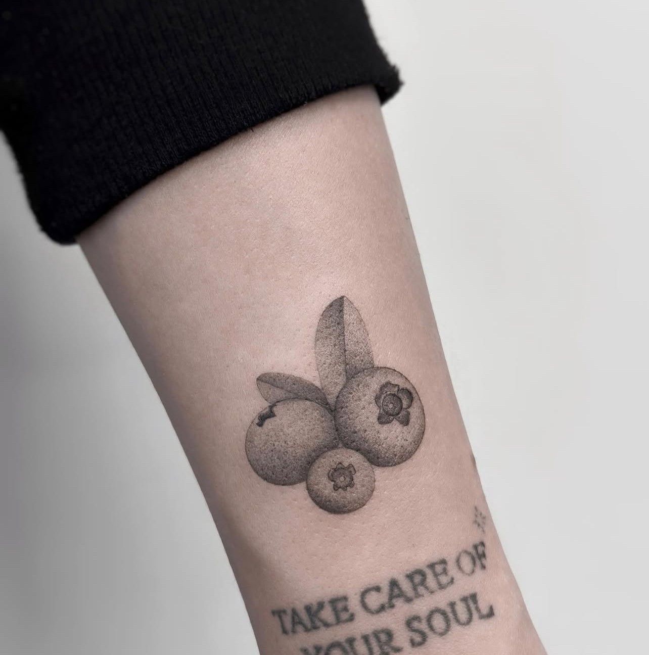 Ein Tattoo auf dem Arm einer Person mit der Aufschrift „Kümmere dich um deine Seele“