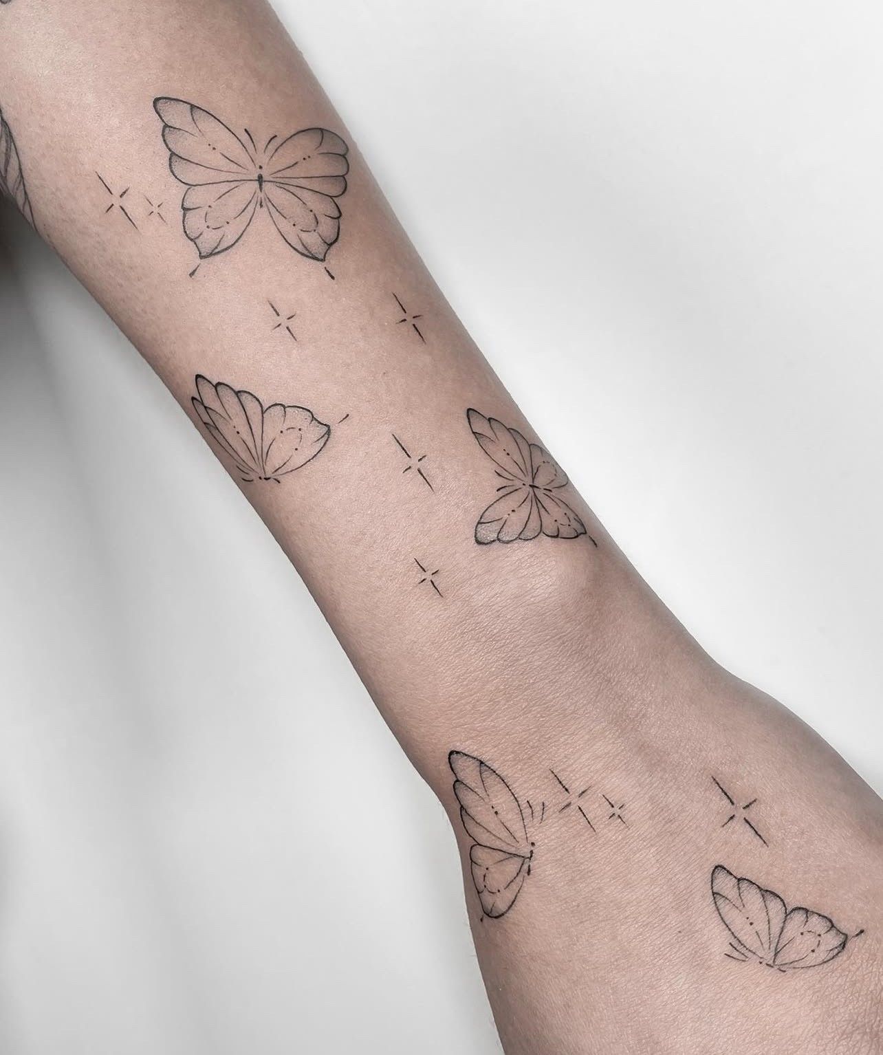 Eine Person hat ein Schmetterlingstattoo auf dem Arm