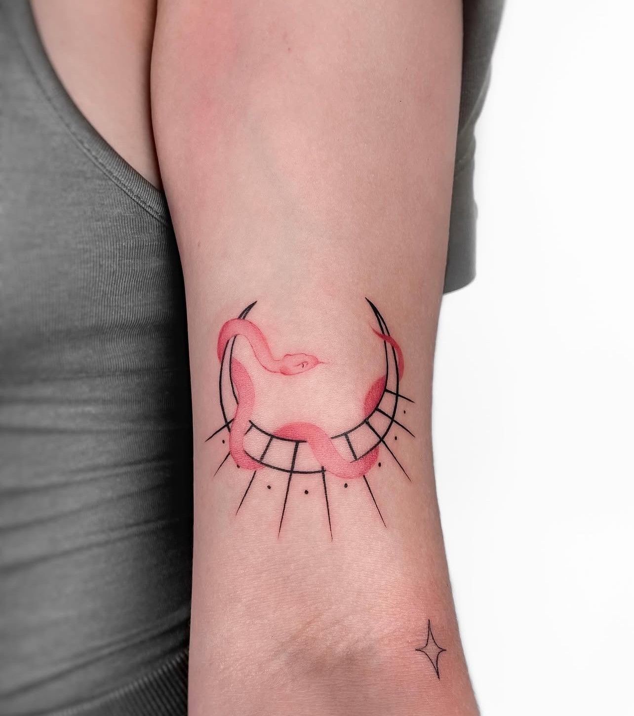 Eine Frau hat eine Schlangentätowierung auf ihrem Arm.