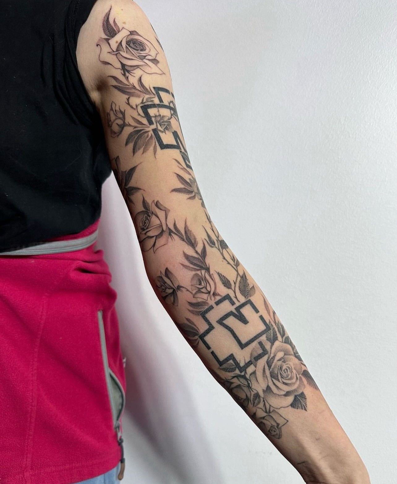 Eine Frau hat eine Tätowierung auf ihrem Arm, auf der steht: