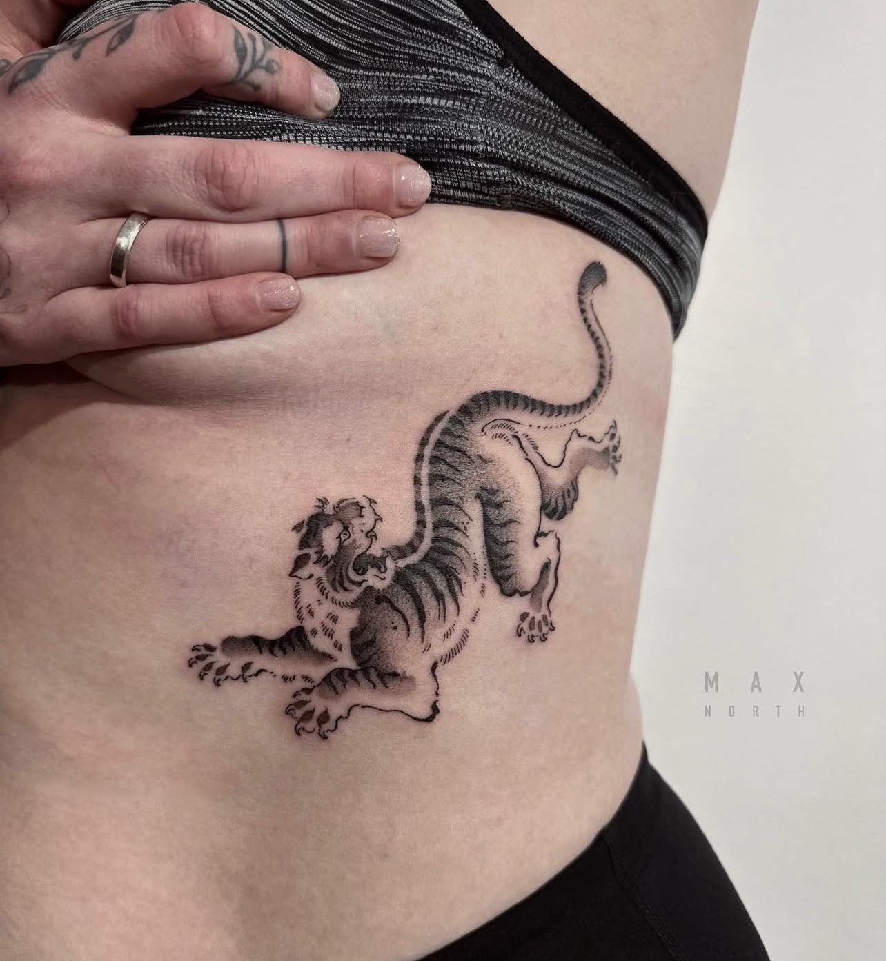 Eine Frau hat ein Tigertattoo auf ihrer Seite