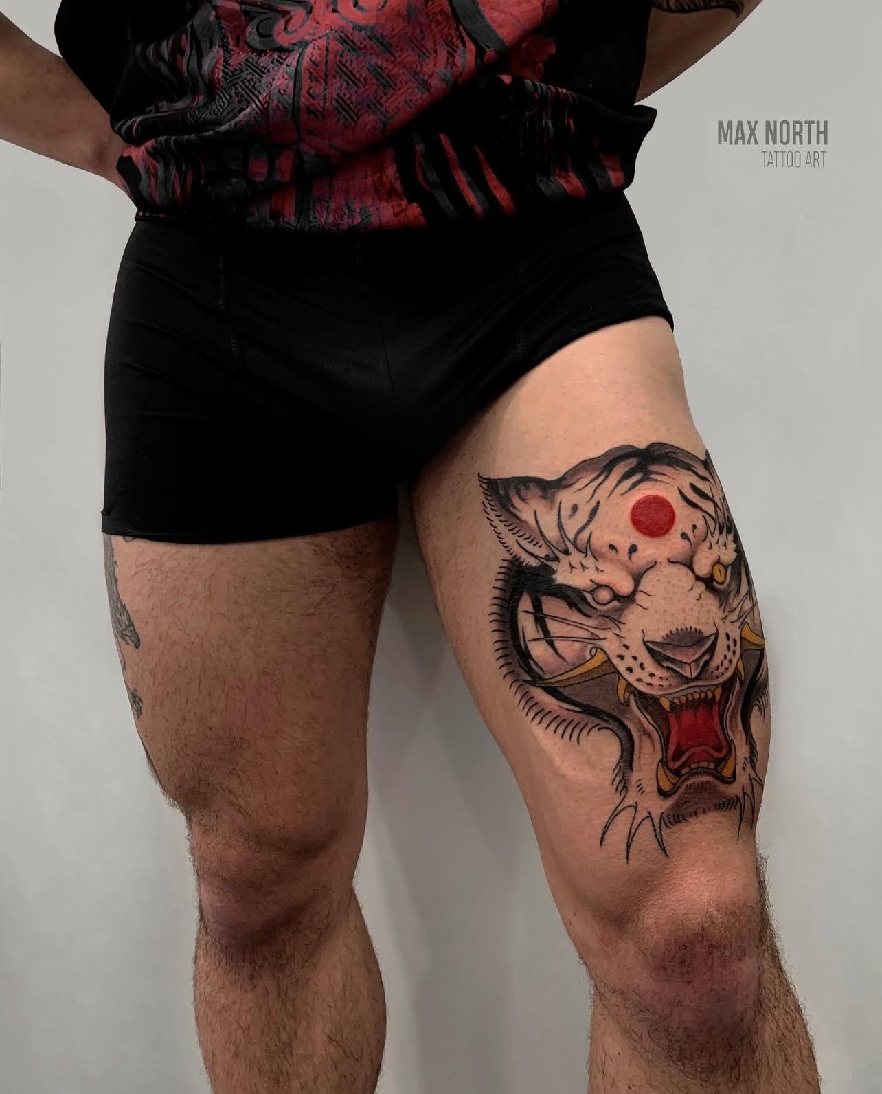 Ein Mann hat eine Tigertätowierung auf seinem Bein.