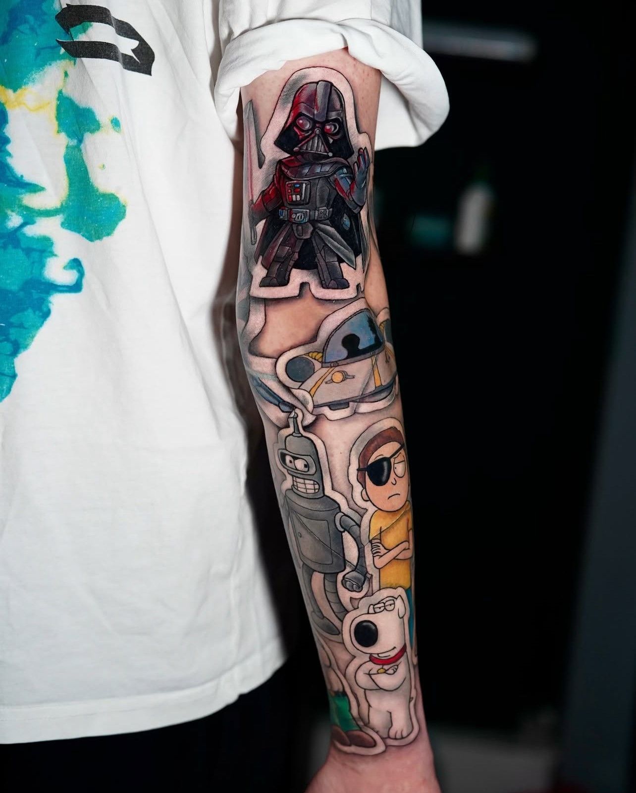 Eine Person hat eine Tätowierung von Rick und Morty auf dem Unterarm.