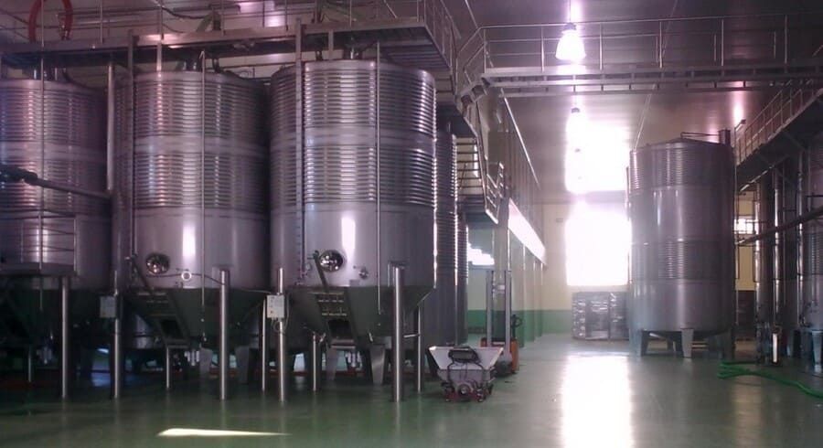 Un almacén lleno de muchos tanques de acero inoxidable.