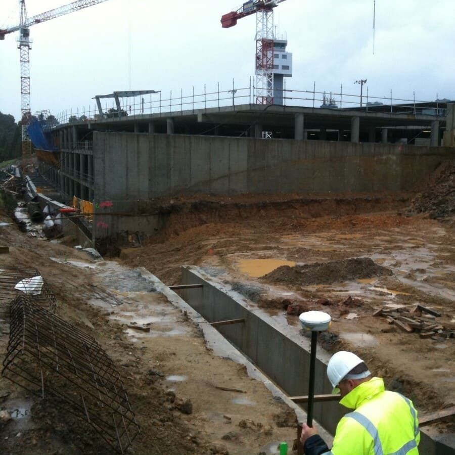 Un hombre con una chaqueta amarilla está trabajando en una obra de construcción.