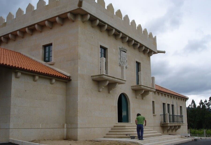 Un hombre con una camisa verde está parado frente a un gran edificio.