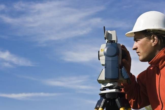 Un hombre que lleva un casco mira a través de un telescopio.